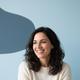 Smiling woman in her late 30s, headshot portrait, representing comfort and satisfaction.